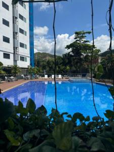 ein großer blauer Swimmingpool vor einem Gebäude in der Unterkunft Hotel Blue 66 in Cali