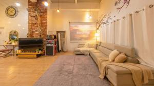 a living room with a couch and a television at Gapyeong Ddel Poolvilla in Gapyeong