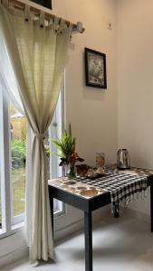 a table in a room next to a window with a curtain at The Winaposa in Munduk