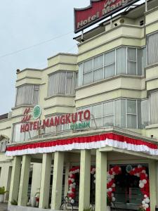 a hotel with a sign on the front of it at Hotel Mangkuto Syariah in Payakumbuh