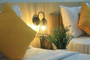 a bedroom with two beds and a lamp and a plant at Hotel Mangkuto Syariah in Payakumbuh