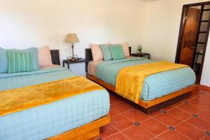 two beds in a room with a tiled floor at Ranchito Buhos in Francisco Zarco