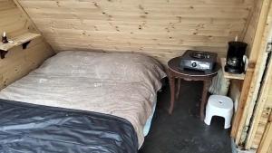 a small bed in a room with a table and a bed sqor at Chalet CAJIK Project, tipo Nordico in Cajicá