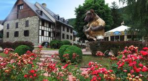 a statue of a bear in a garden in front of a building at VVF Saint-Lary-Soulan Hautes-Pyrénées in Saint-Lary-Soulan