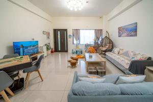 a living room with a blue couch and a tv at Sunlight Orchid Rain Homestay in Dongshan