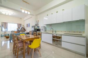 a kitchen with a table and yellow chairs in it at Sunlight Orchid Rain Homestay in Dongshan