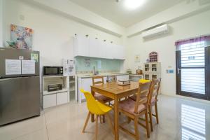 a kitchen with a wooden table and yellow chairs at Sunlight Orchid Rain Homestay in Dongshan +18 photos