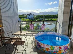 a hot tub on a balcony with a table and chairs at Sunlight Orchid Rain Homestay in Dongshan