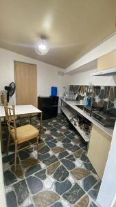 a room with a table and a kitchen with a floor of rocks at Eco Homes in Panglao Island