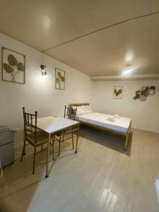 a room with a bed and a table and chairs at Eco Homes in Panglao Island +1 photo