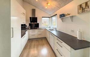 a kitchen with white cabinets and a black counter top at Lovely Home In Haderslev With Sauna in Haderslev