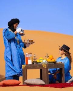 two women are standing in front of a table at Authentic Desert Luxury Camp in Merzouga +56 photos