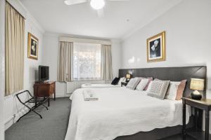 a bedroom with a large bed and a television at Lancefield Guest House in Lance Field
