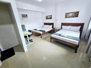 a hotel room with two beds and a desk at Matilde B&B - La Paz, Carmen in Carmen