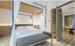 a bedroom with a large bed and a chair at 弗克斯酒店 in Zunyi