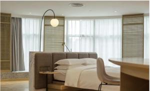 a bedroom with a bed and a table with a chair at 弗克斯酒店 in Zunyi