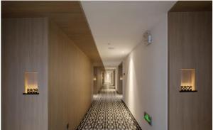 a hallway with a long corridor with lights on the walls at 弗克斯酒店 in Zunyi