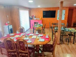 a dining room with a table and chairs and a television at Hospedaje Fer-Mar in Castro