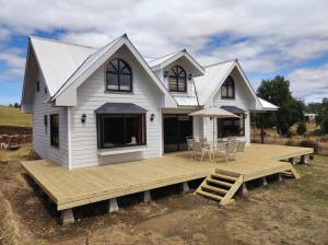 a large white house with a wooden deck at Hospedaje Fer-Mar in Castro