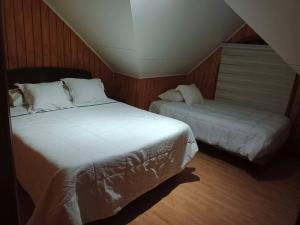 a bedroom with two beds and a window at Hospedaje Fer-Mar in Castro