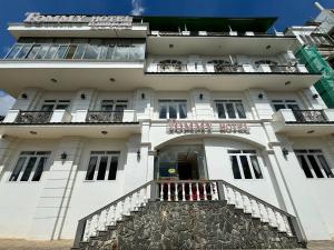 a large white building with a balcony at Tomy Khe Sanh Đà Lạt in Ấp Ða Lợi