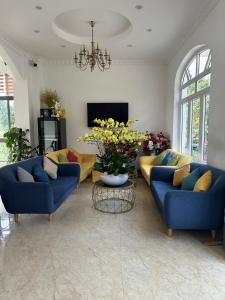 a living room with two blue couches and a table at Tomy Khe Sanh Đà Lạt in Ấp Ða Lợi
