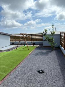 a playground in a garden with a swing at Villa hibiscus in Sainte-Suzanne