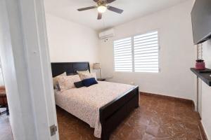a bedroom with a bed and a ceiling fan at Villa Zoed in San Juan