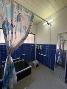 a bathroom with a sink and a shower curtain at Hareumi in Tamano