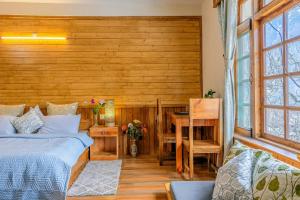 a bedroom with a bed and a desk and a table at Zeyul Homes in Manāli