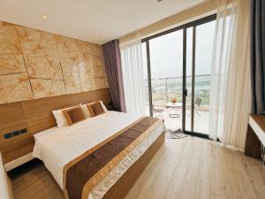 a bedroom with a bed and a large window at Apec Mandala Tuy Hòa Phú Yên Tina House in Ðông Tác (1)