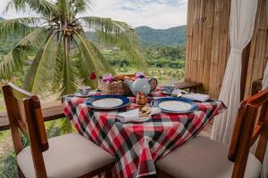 a table with a plate of food and a palm tree at LeLangit Eco Cabin in Sidemen +10 photos