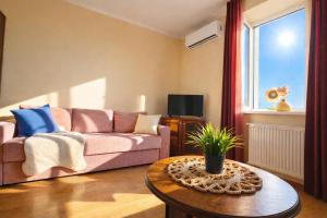 a living room with a pink couch and a table at Best Two Room Apartment in Mukacheve