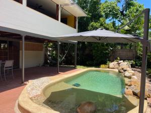 a swimming pool with an umbrella and a house at Horseshoe Haven in Horseshoe Bay +22 photos