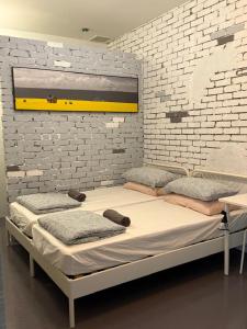 a large bed in a room with a brick wall at HuttonSTAY at Georgetown in George Town