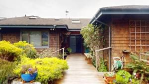 a house with a wooden walkway leading to a blue door at Windrose in Fort Bragg