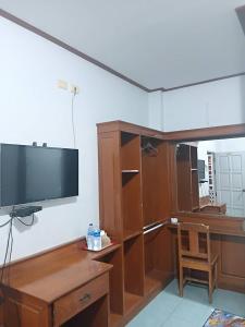 a room with a flat screen tv on a wall at Middle Road Hostel in Nathon Bay
