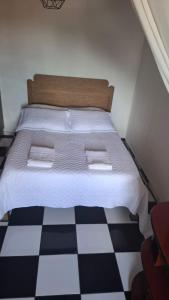 a bedroom with a bed with a checkered floor at Kitnet Duplex Ibiúna in Ibiúna