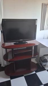 a flat screen tv on a red stand on a floor at Kitnet Duplex Ibiúna in Ibiúna