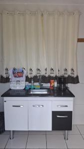 a kitchen counter with a sink and a curtain at Kitnet Duplex Ibiúna in Ibiúna +8 photos