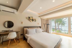 a bedroom with a bed and a desk and a window at SEA TO SKY Villa - 4 Bedrooms Ocean View in Pulau Nongsa