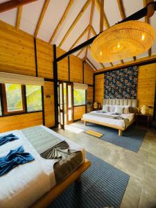a bedroom with two beds in a room with wooden walls at Treetops ella in Ella