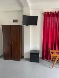 a room with a tv and a red curtain at Scenic View - Ella in Ella