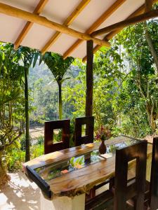 a wooden table and chairs under an umbrella at Treetops ella in Ella
