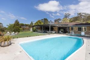 a swimming pool in front of a house at Ekhaya Homestead Berry in Wattamolla