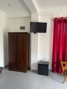 a room with a wooden cabinet and red curtains at Scenic View - Ella in Ella +17 photos
