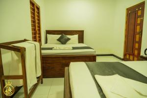 a bedroom with a bed and two beds at T P Villas in Nilaveli
