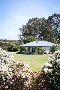 a white house with a garden and flowers at Red Door Collective - RDC Vineyard Estate, Luxury Adult Only Stay in Pokolbin