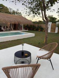 a patio with two chairs and a table and a pool at Lasa, private villa with private pool in El Nido