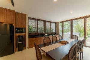 a kitchen with a large wooden table and chairs at SEA TO SKY Villa - 4 Bedrooms Ocean View in Pulau Nongsa